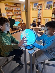 Foto Kinder mit Globus in Schulbücherei