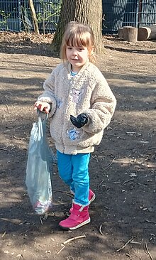 Foto Kind mit Mülltüte